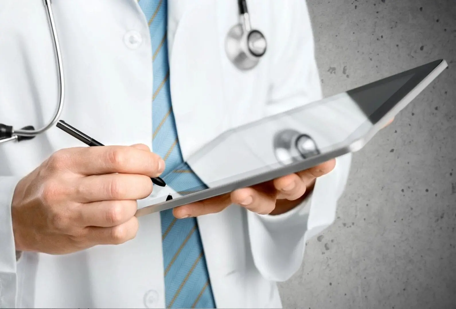 Doctor wearing a lab coat tapping on a tablet with a stylus